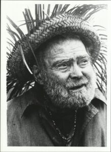 The Fort Fisher Hermit wearing straw hat, love beads and shirt.