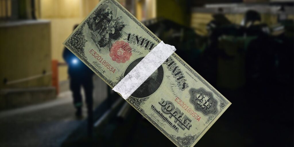 Taped 1917 dollar bill over blurred photo of night watchman.