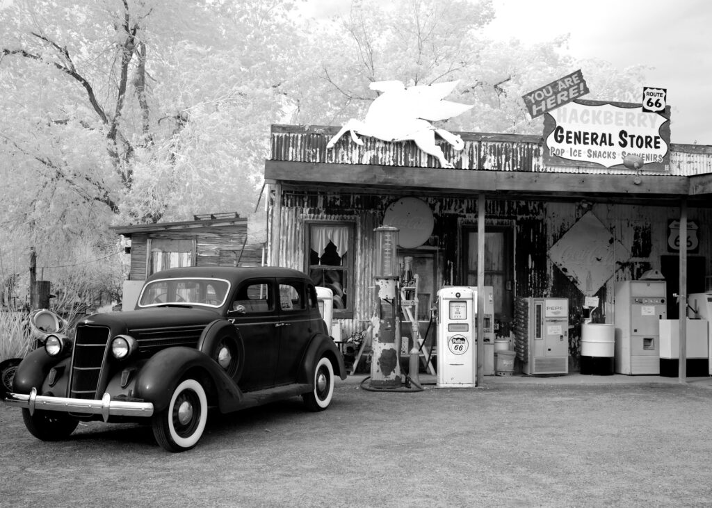 Vintage car parked in front of a general store