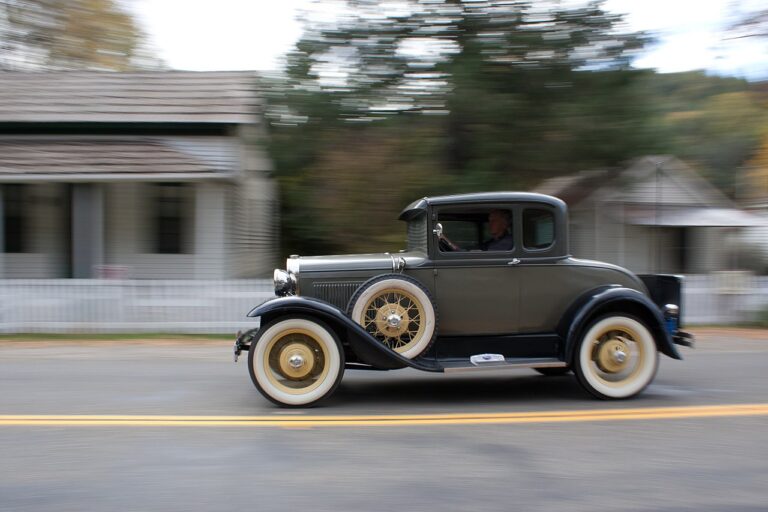 Photo of a 1930s Ford car speeding through a town.